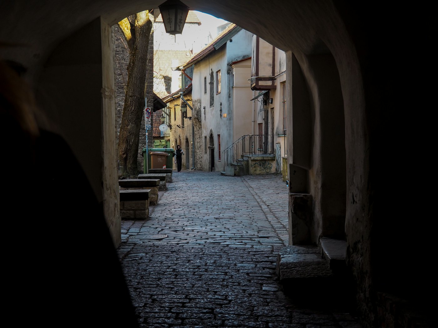 Cobbled street in Tallinn old town seen through an archway